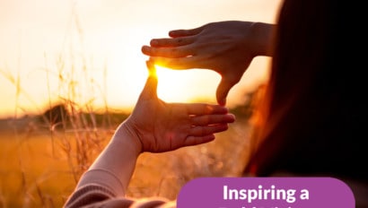 woman with hands holding sun on horizon